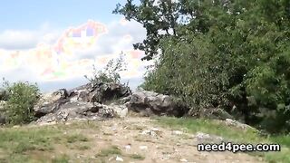 Sporty blonde gets down for a piss on the rocks